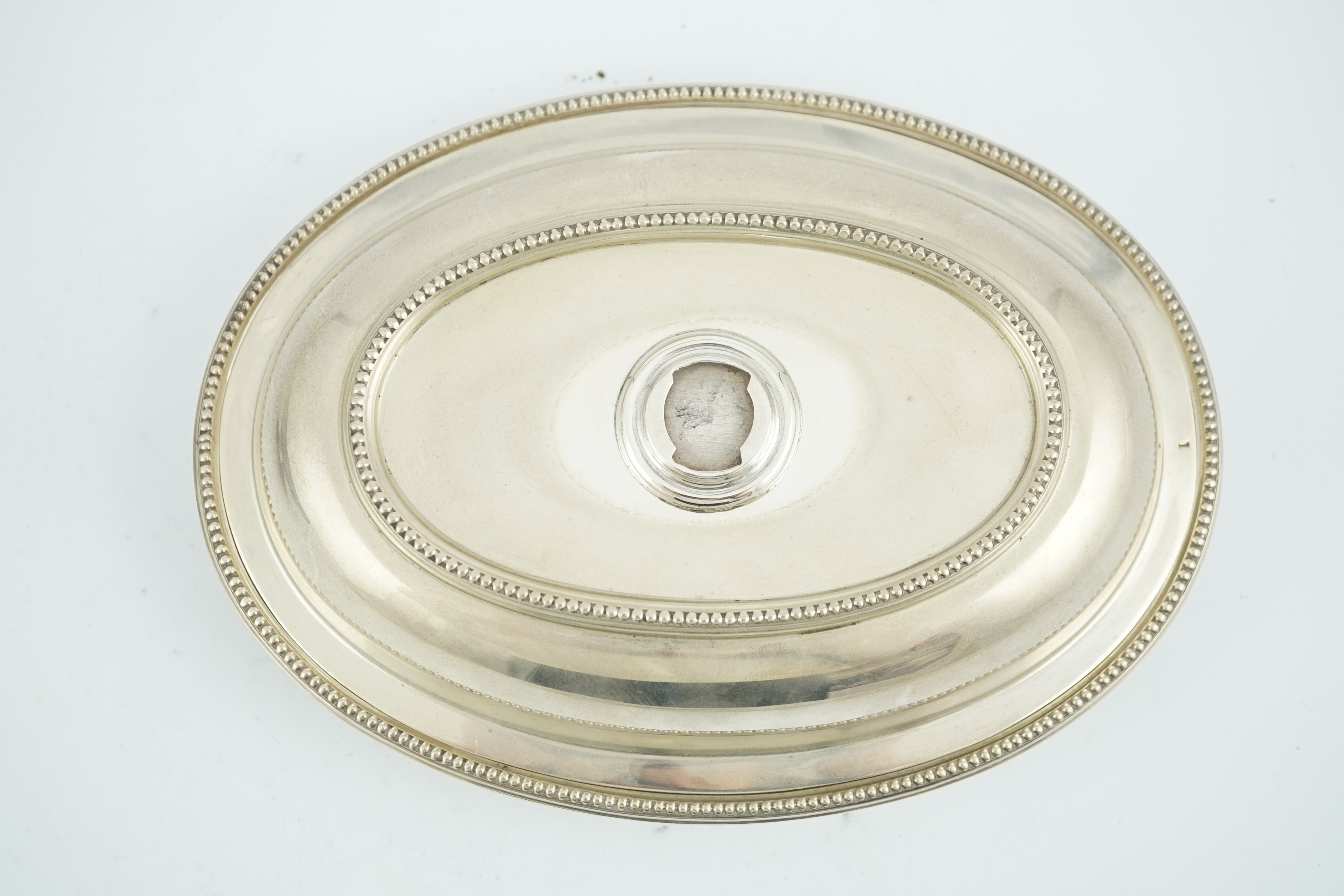 An Edwardian silver oval entreé dish and cover, lacking handle, by Goldsmiths & Silversmiths Co Ltd